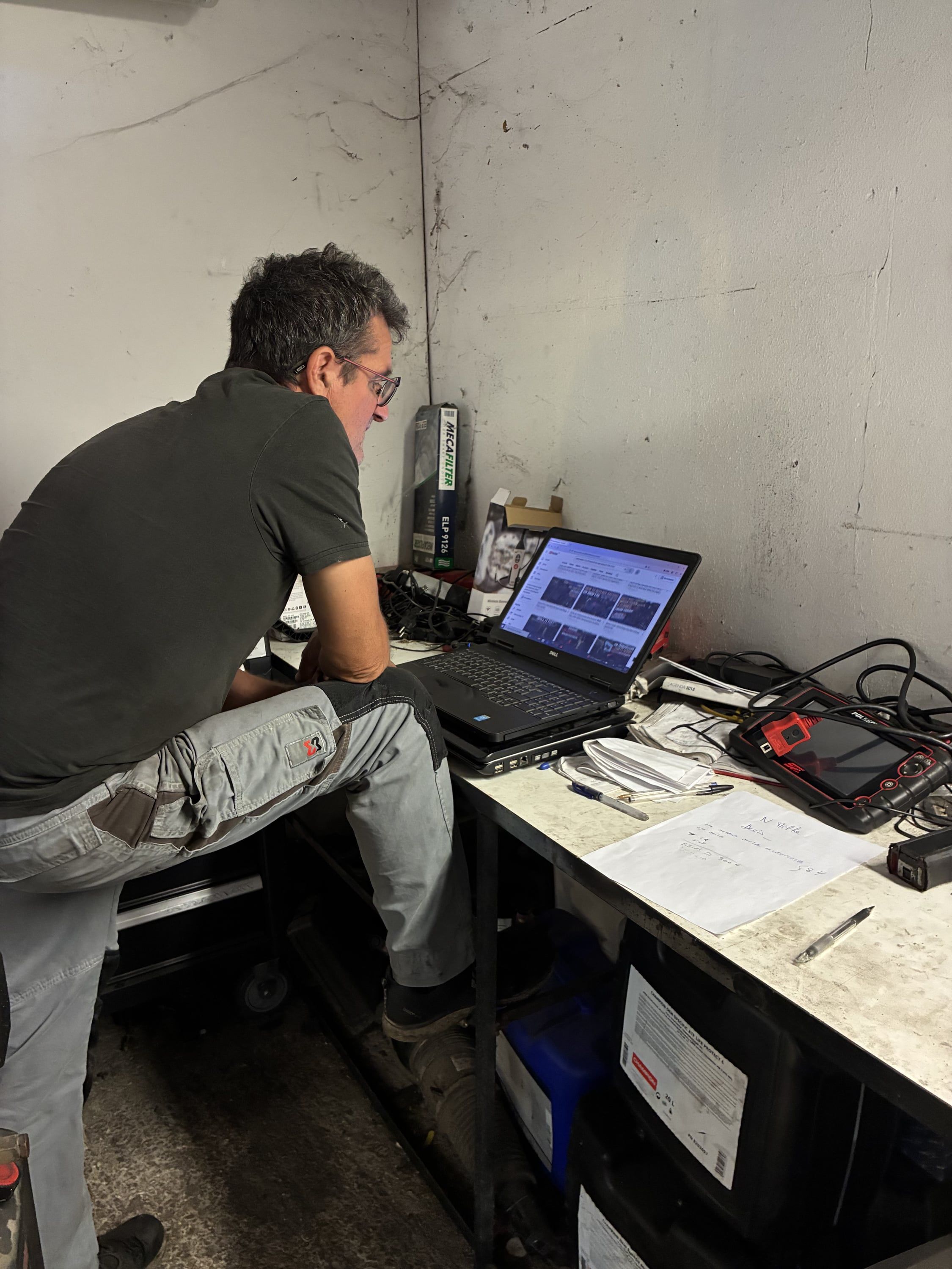 Olivier, mécanicien de Meca Sports, au poste de diagnostic électronique de l'atelier